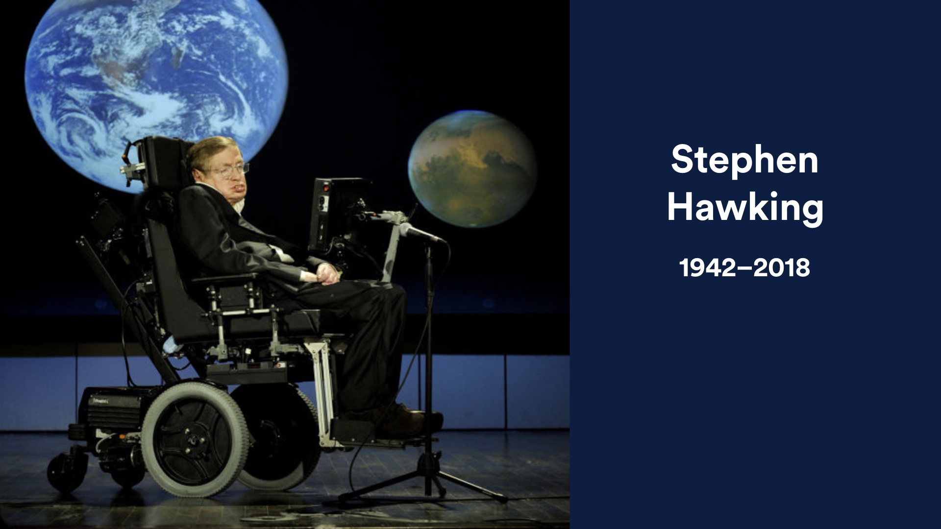 Slide image: photo of Stephen Hawking on stage with planets behind him on screen